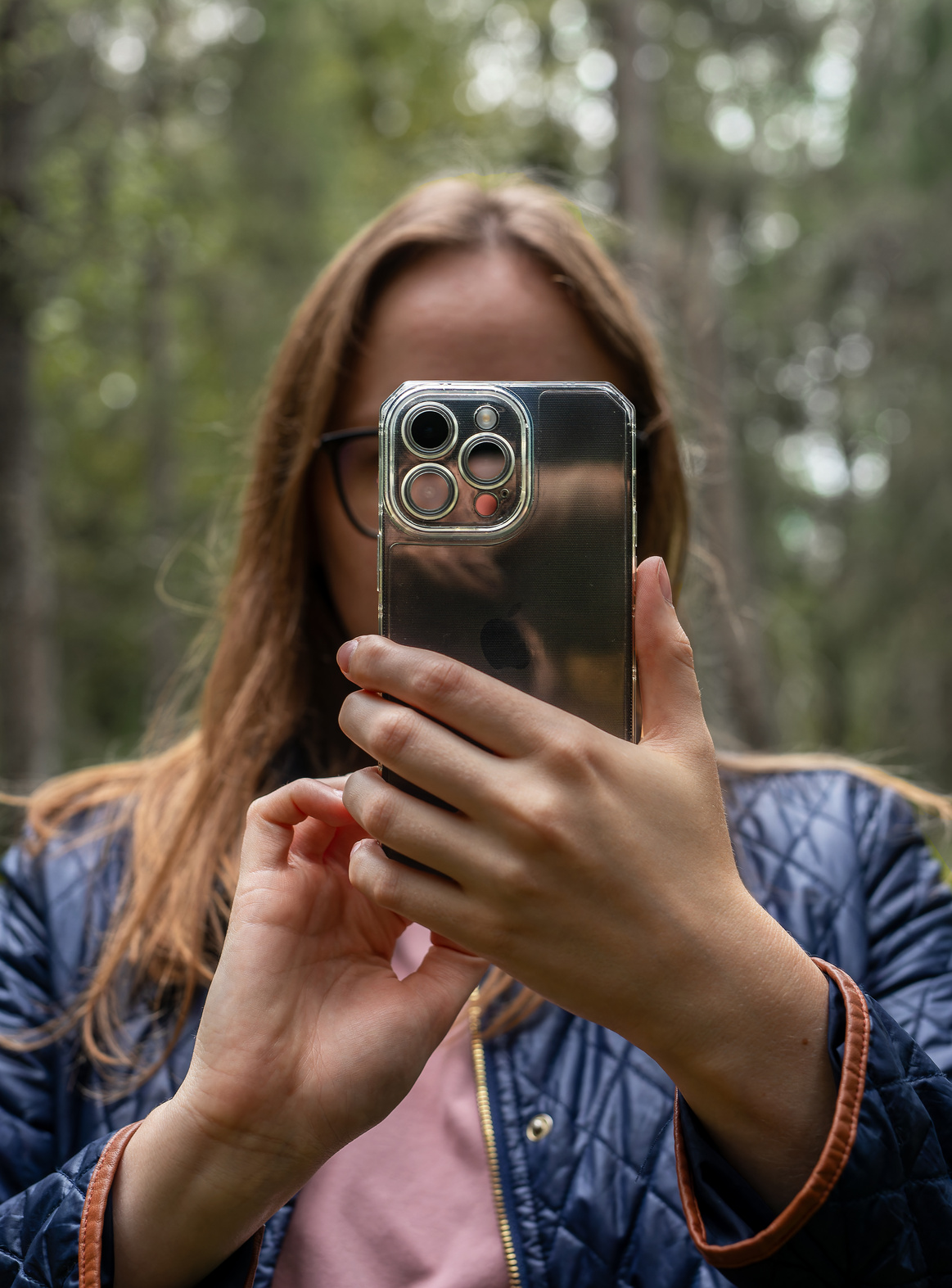 Berlin, Germany October 30 2023 Woman covering face with mobile phone, taking photo of nature