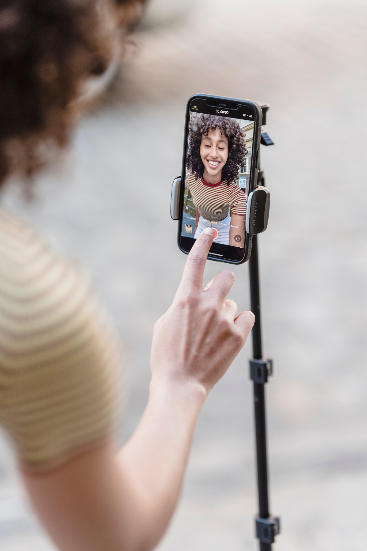 Ethnic woman recording live broadcast on street